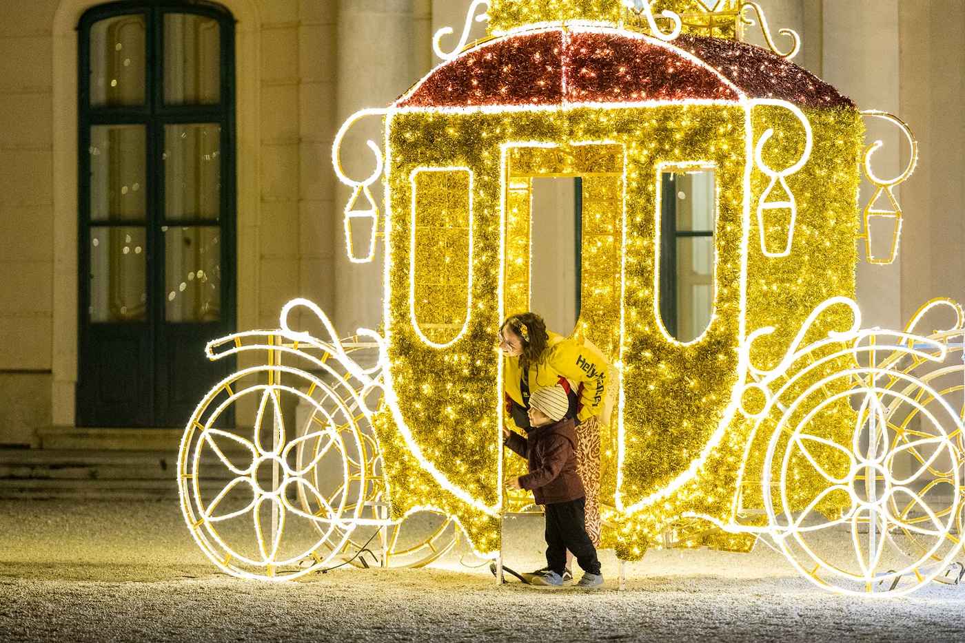 Eine goldene Kutsche aus Licht vor der Schlossmauer, ein Kind sitzt darin